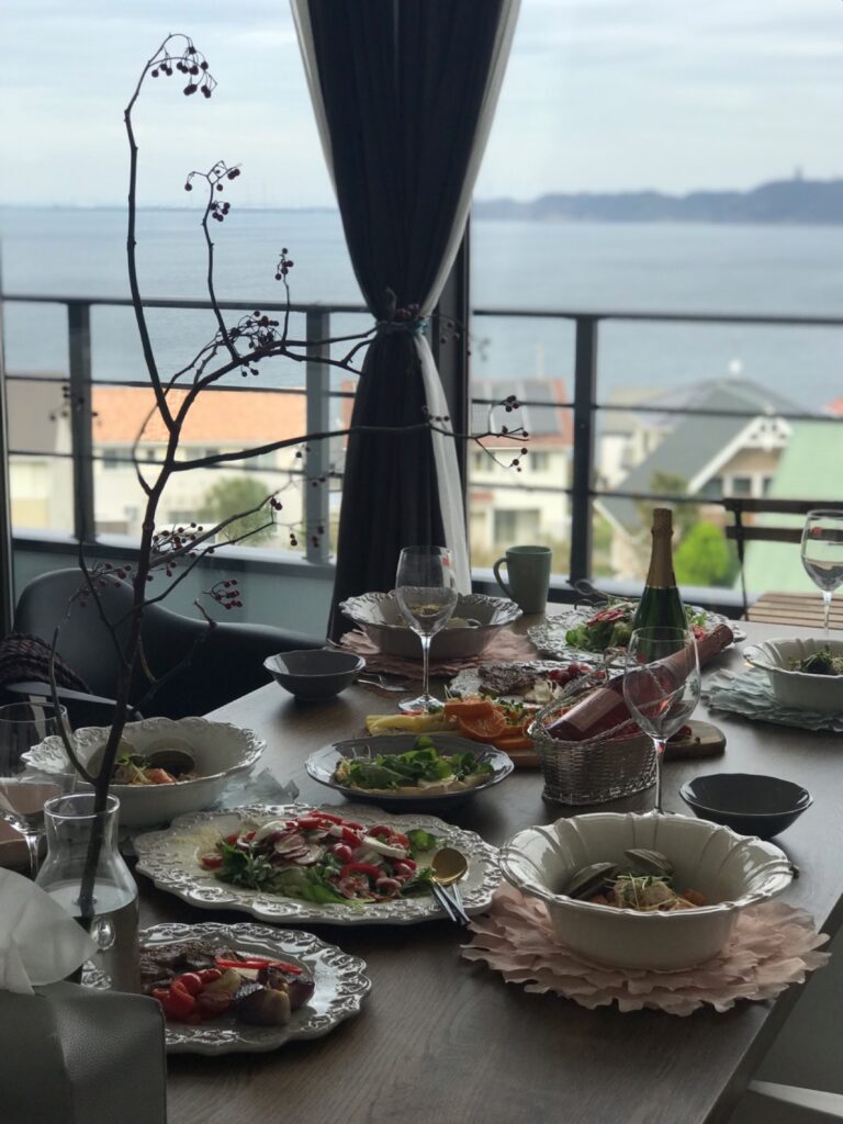 바다가 보이는 창가 식탁에 여러 요리가 차려진 모습